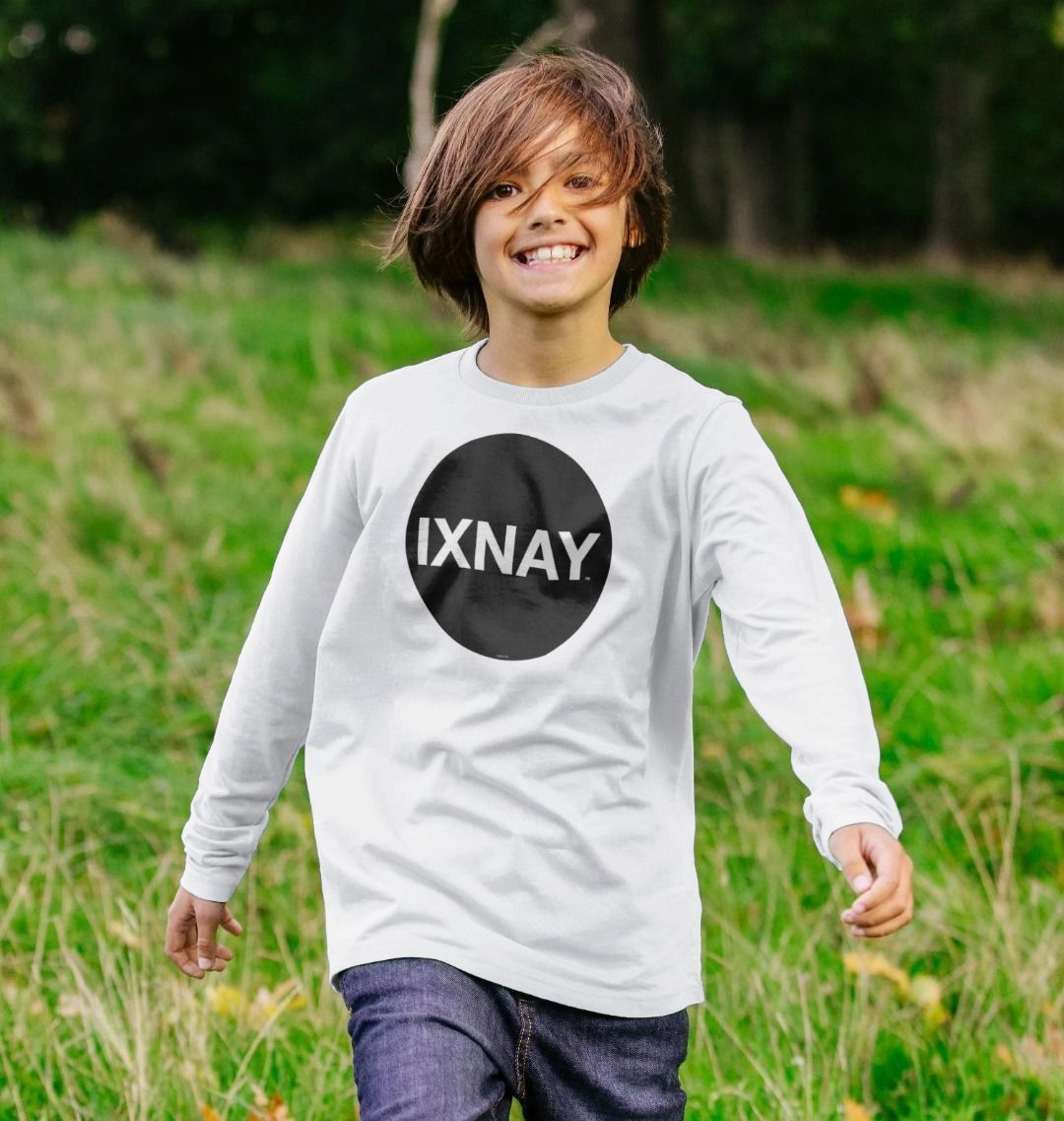 Boy playing in field while wearing a kids white organic long-sleeved t-shirt with original black round IXNAY logo