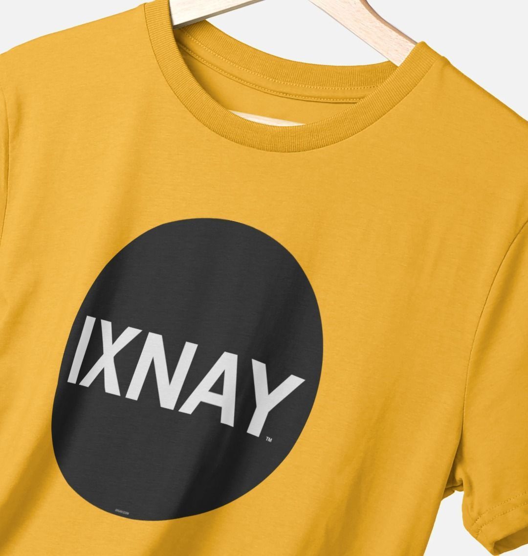 Closeup of a mustard yellow t-shirt on a clothes hanger. The Printed Men's T-Shirt with Original Black Round IXNAY Logo with the phrase REJECT REJECTS REJECTOR on back  to represent the artist and musician IXNAY