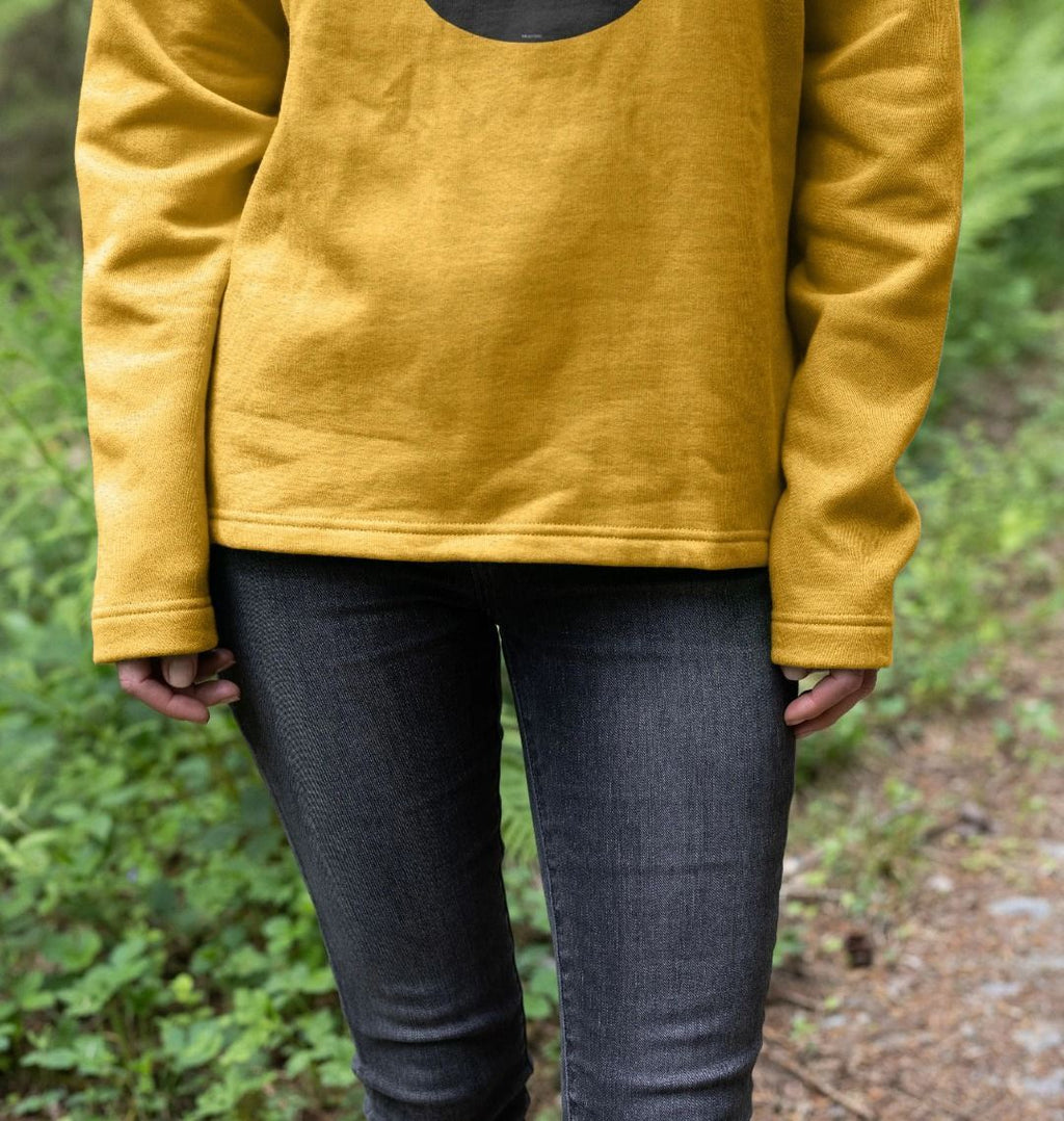 detail image showing a flattering curvy hem of womens sunflower yellow organic remill pullover hoodie with original black round IXNAY logo
