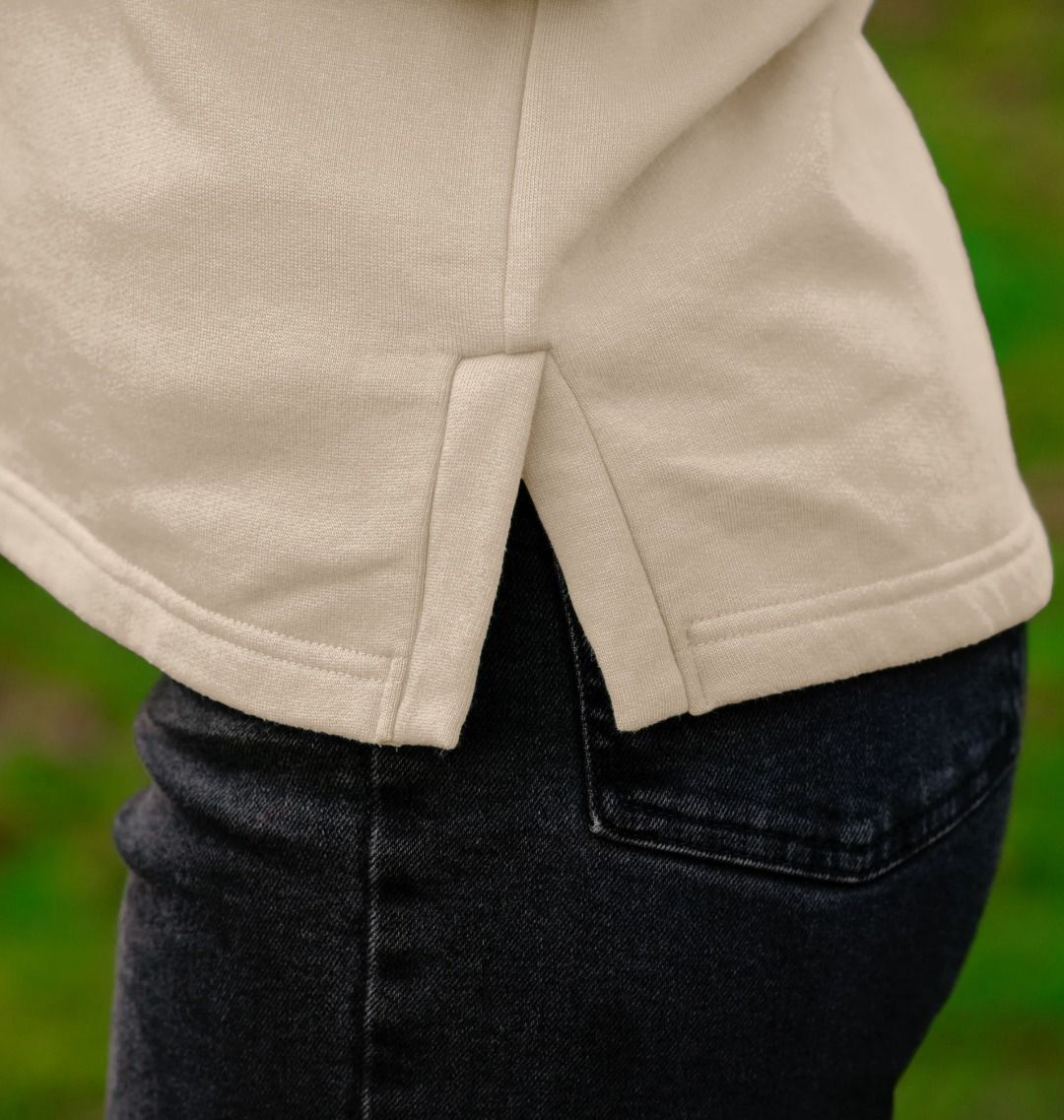 detail image of side splits and curve enhancing hem on womens organic pullover hoodie with original black round IXNAY logo