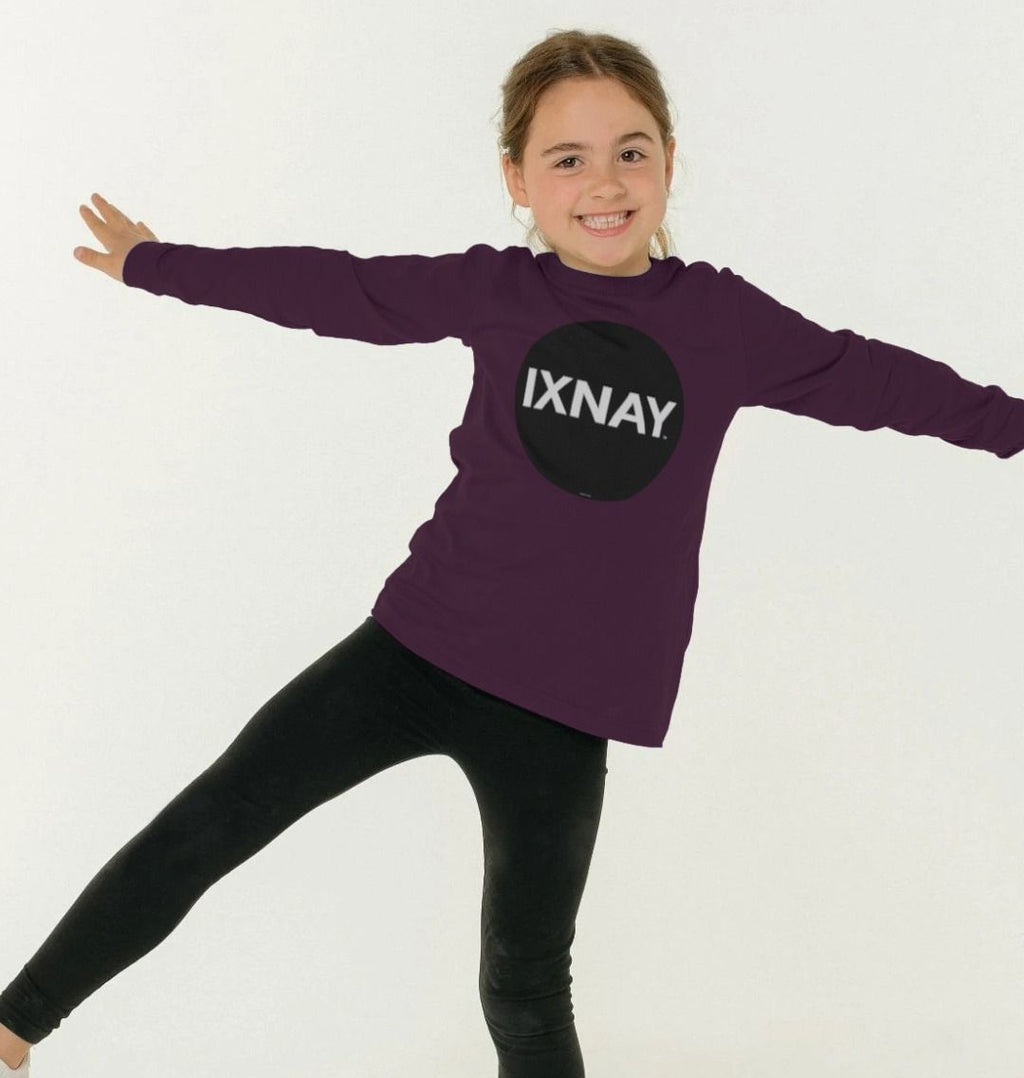 Girl smiling and having fun while wearing a kids purple organic long-sleeved t-shirt with original black round IXNAY logo