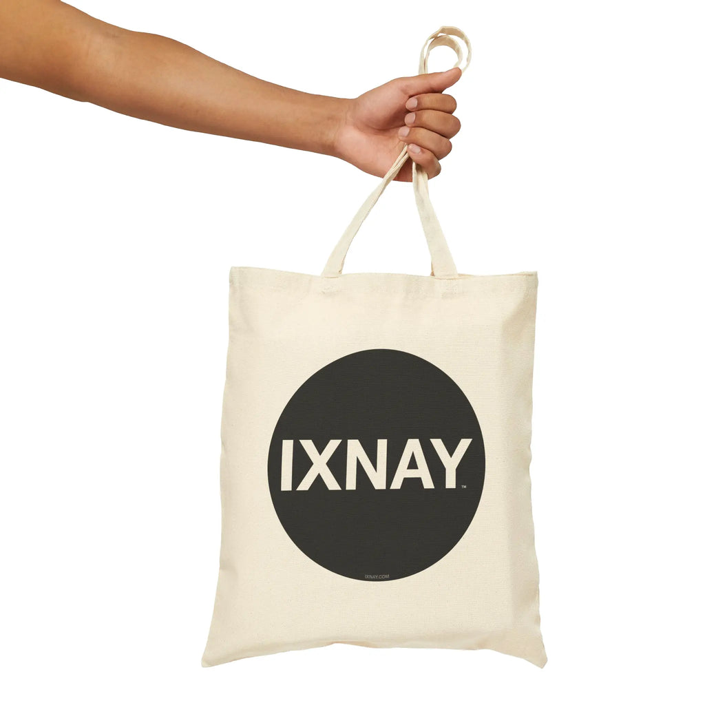 100% cotton natural canvas tote bag with 'IXNAY' original logo held by a hand to show size.