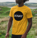A man models a mustard yellow t-shirt with a black circular logo that reads 'IXNAY' on the front.