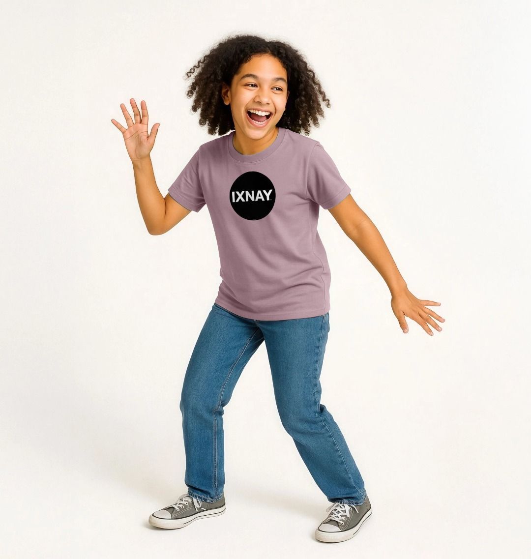 Laughing mixed race girl dancing and being silly for photoshoot against all white background wearing a mauve t-shirt with the original IXNAY black circular logo printed on the front