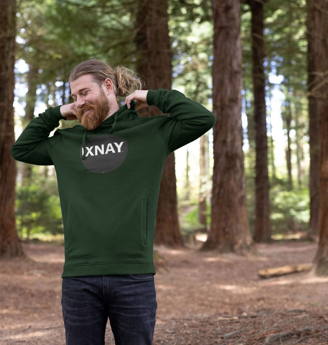 Man walking in woods wearing mens dark green organic cotton pullover hoodie with original black round IXNAY logo