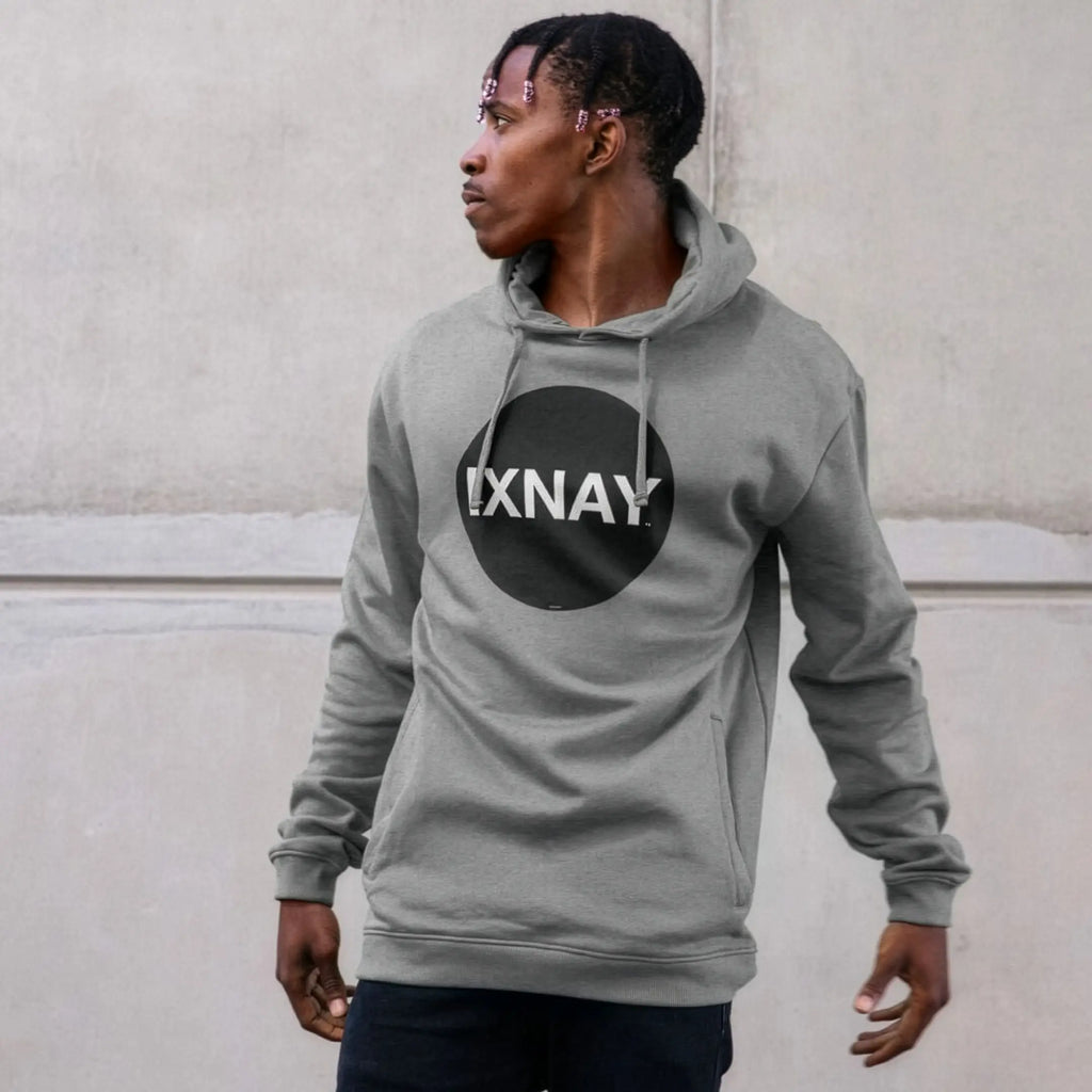 Man in urban concrete structure wearing mens light heather gray organic cotton pullover hoodie with original black round IXNAY logo.