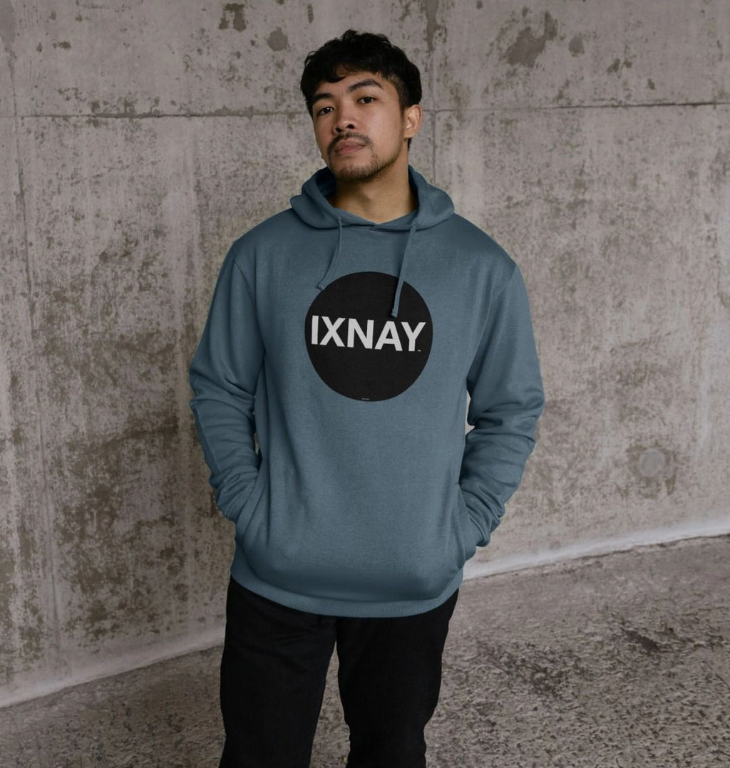 Man in urban concrete structure wearing mens stone blue organic cotton pullover hoodie with original black round IXNAY logo