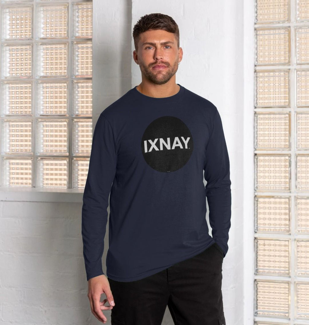 Man standing in front of wall of glass bricks wearing navy blue Printed Men's Long-sleeved T-Shirt with Original Black Round IXNAY Logo from the artist and musician IXNAY