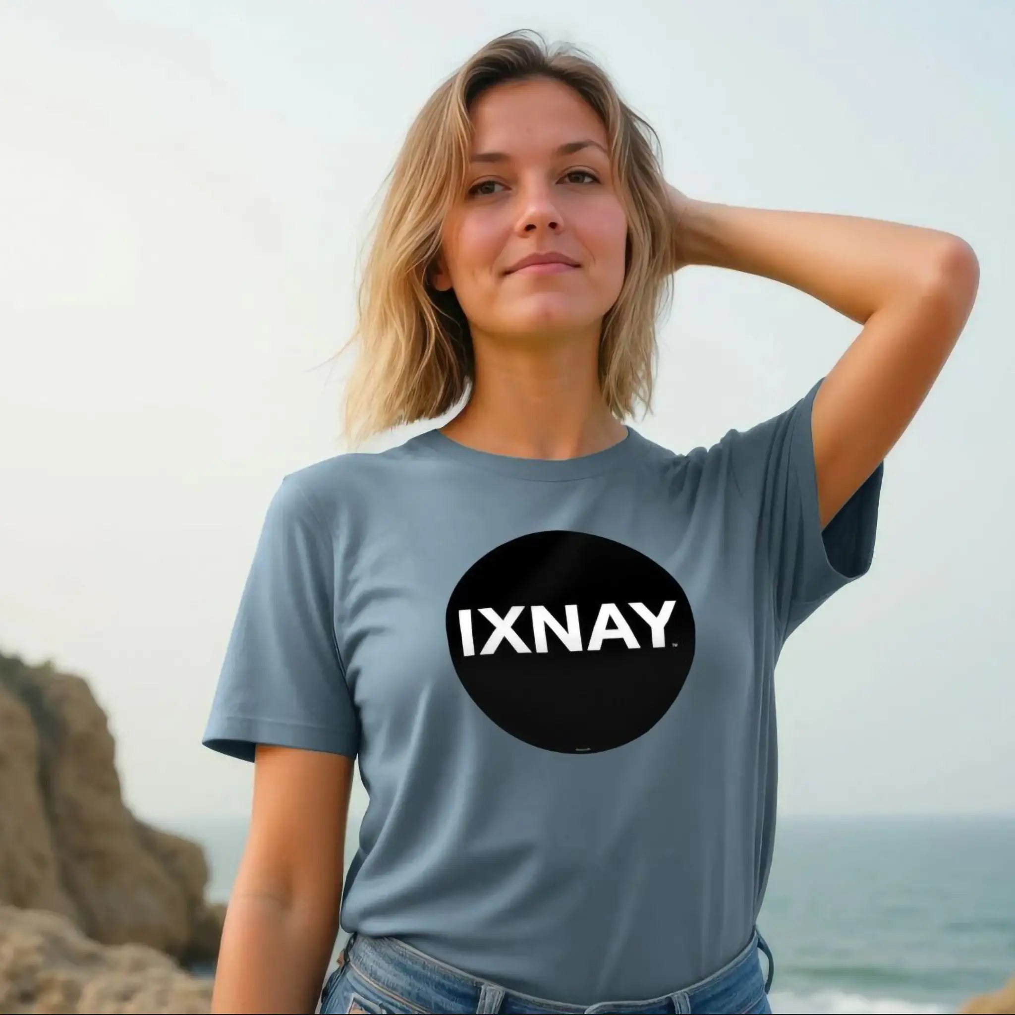 Woman wearing women's short-sleeve slate blue t-shirt with 'IXNAY' original black circle logo in 100% organic cotton.