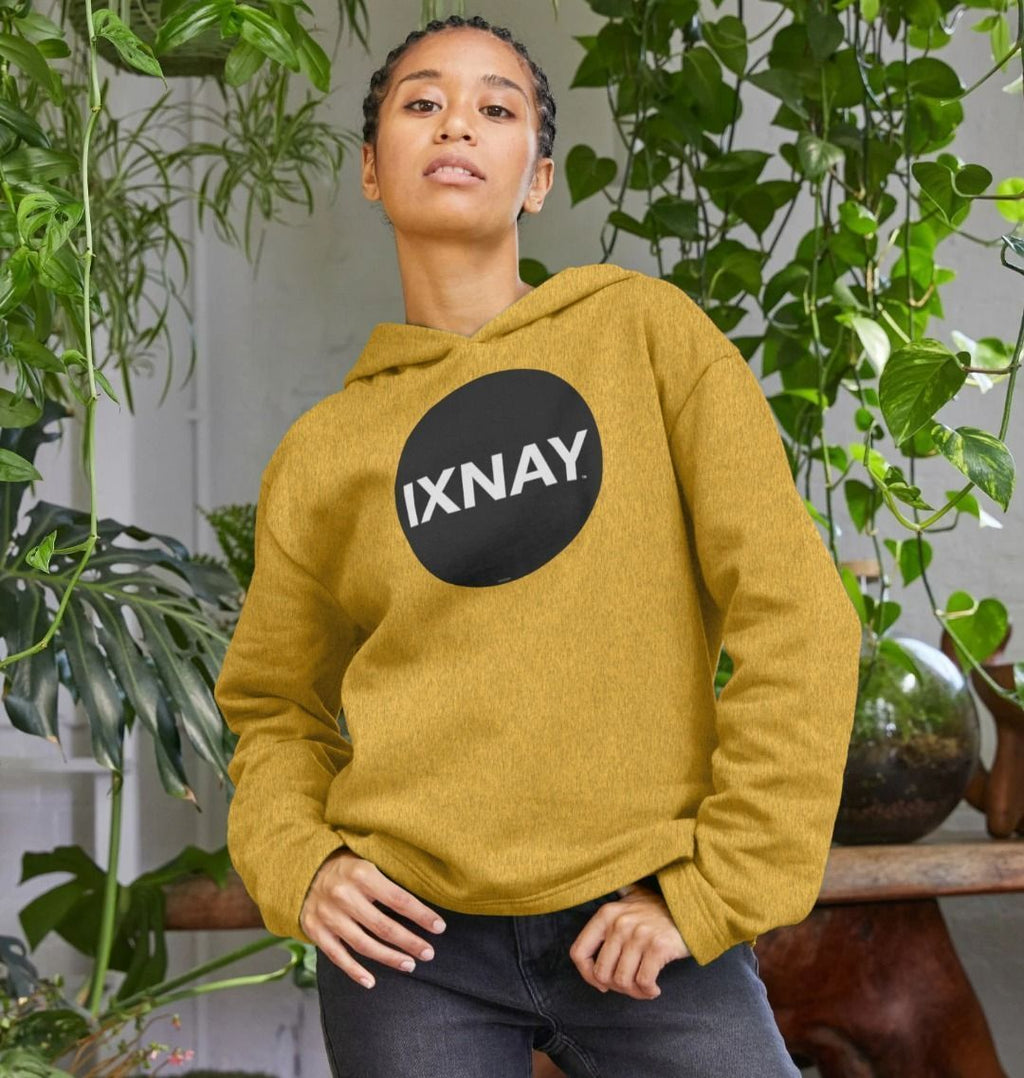 woman with cornrows in plant-filled room wearing womens sunflower yellow organic remill pullover hoodie with original black round IXNAY logo