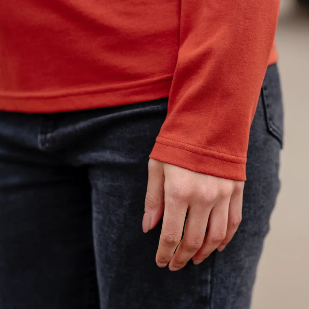 Detail image of cuff on IXNAY long-sleeve shirt and dark jeans with a blurred background
